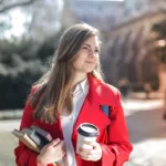 студентка з книгами та чашкою кави
